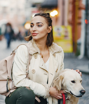 a girl walking a dog in the city